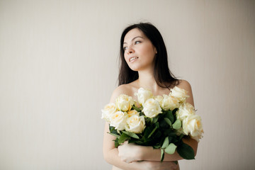 Portrait of an attractive young woman holding bouquet of roses.