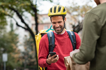 Delivery man checking food order with smartphone