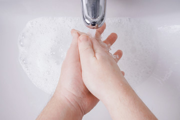 washing hands with soap and water from personal perspective - hygiene concept with unrecognizable...