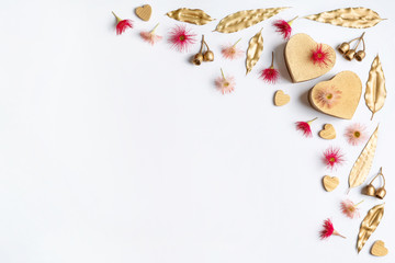 Gold heart shaped gifts decorated by gold eucalyptus leaves and gum nuts, gold hearts, flowering pink/red gum nuts, on a white background. Gifts for, Birthday , Christmas, Mothers or Anniversary.	