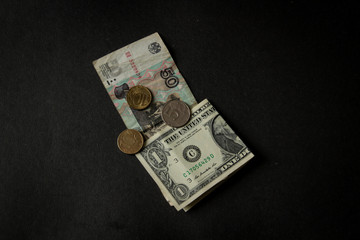 Money, dollars and rubles, american dollar, russian ruble. On a black background. U.S. dollars.