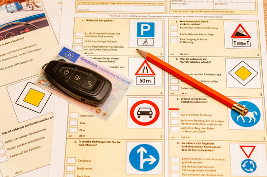 Führerschein, Autoschlüssel und Bleistift auf einem Fahrschulbogen