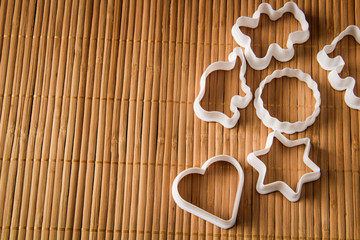 plastic molds for baking cookies in the form of hearts, stars, circle, elephant, hippo and bear, on wooden background