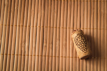 wine cork, on a wooden background with a picture of grapes