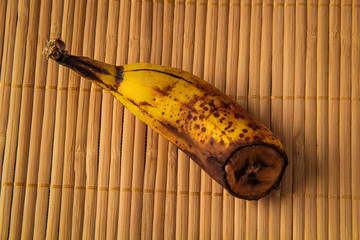 Banana, half banana, spoiled banana on a in wooden background. Organic waste overripe fruit.