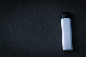 White plastic gas lighter. Gas lighter on black background. Closeup shot, top view