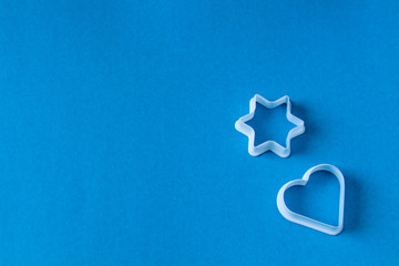 plastic molds for baking cookies in the form of  hearts and stars on a blue background