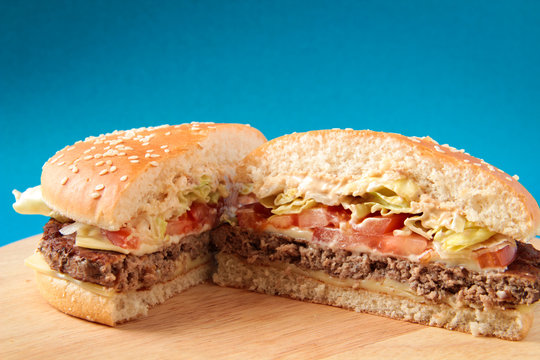 Split Burger On A Wooden Board, On A Blue Background, Hamburger, Fast Food