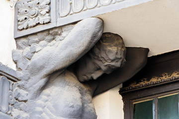 Sculpture of a man on the facade of an old building.