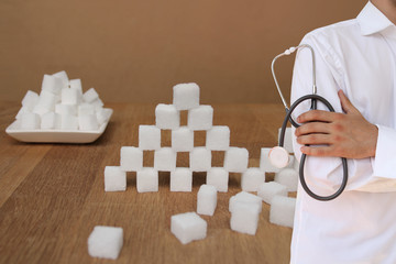 dietitian doctor in white uniform with a stethoscope in his hands, followed by a high sugar pyramid...