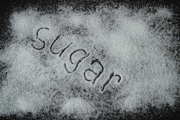 white sugar on a black background, the inscription sugar