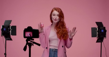Beautiful female Model working at Studio, demonstrating Great product, popular Creme. Enjoying her job. Looking Happy and trying to show her Best. Many devices around Model. Making video Shots.