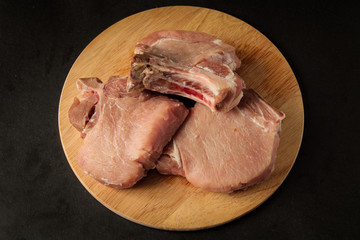three pieces of raw meat lie on top of each other, steaks, at a given address with a black...