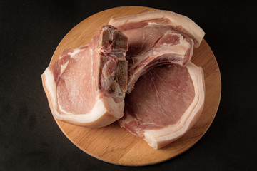 three pieces of raw meat on a wooden board