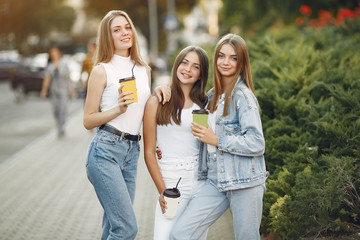 Beautiful girls walking. Women in a spring city. Ladies drinking a coffee.