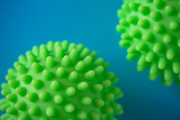 Close up of two green spiky coronavirus models isolated on blue background. Pandemic desease spreading worldwide. Medical treatment of the infected people. Healthcare