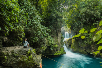 Bridge of God Waterfalls San Luis Potosí - January 19, 2020: people watching and taking pictures of the beautiful blue waterfall in the middle of the tropical forest