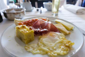 Fried egg Serrano ham and cheese with portion of Spanish omelette
