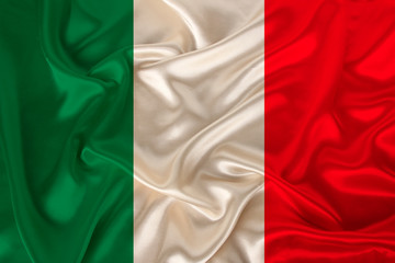photo of the national flag of Italy on a luxurious texture of satin, silk with waves, folds and highlights, close-up, copy space, concept of travel, economy and state policy, illustration