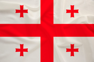 national flag of the country of Georgia on the gentle silk with folds from the wind, the concept of...