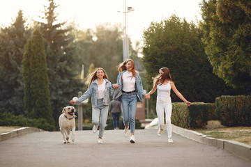 Fototapeta premium Beautiful girls walking. Women in a spring city. Ladies with cute dog.