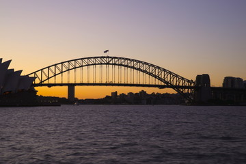 Panorama View of Sydney Harbour bridge opera house on a warm summer afternoon blue and orange skies illuminating Sydney Harbour Bridge