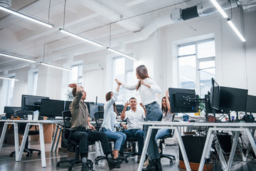 People talking and working together in the modern office near computers
