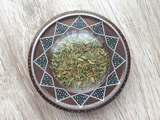High quality seeds of fennel spice. Iranian fennel seeds into handcraft box on wooden background....