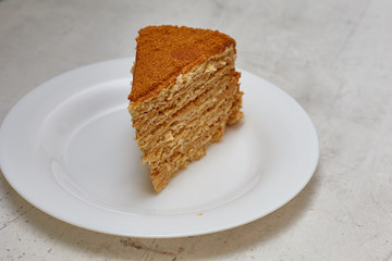 piece of honey cake on a white plate. Minimalism