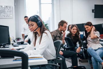 Inside of call center. Young business people working together in the modern office
