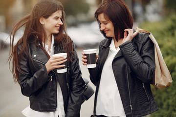 Beautiful girls in a summer city. Ladies with shopping bags. Mother with daughter drinking a coffee.