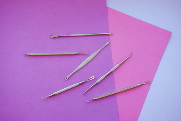 Tools for removing acne. Tools of the cosmetologist for problem skin on pink paper background.