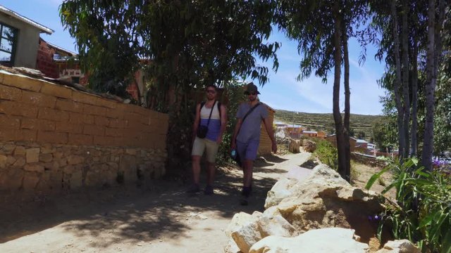 Two male travelers walk through frame - on Isla del Sol, Bolivia