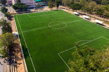 Aerial drone top view of mini football soccer field with playing people.