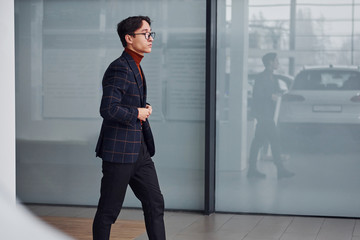 Young business man in luxury suit and formal clothes is indoors in the office