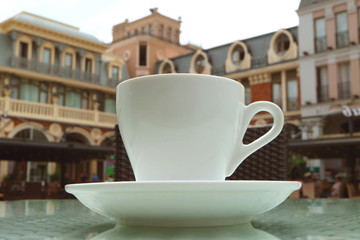 Closeup a cup of coffee with blurry vintage architecture in the backdrop