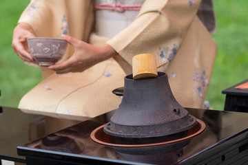 Fototapeta na wymiar Woman in kimono performs Japanese tea ceremony
