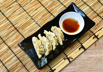 Fototapeta na wymiar steamed Gyoza or Japanese dumpling stuffed minced pork dipping shoyu sauce on plate