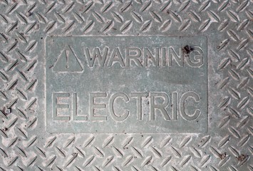 A close view of the metal electric warning sign.