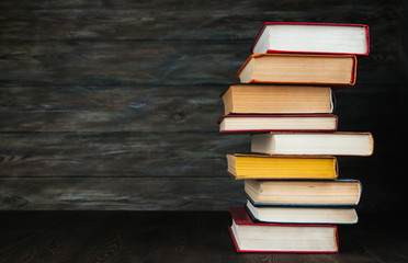 A stack of old books on a wooden background copy space.