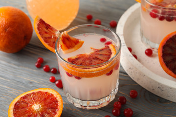 Lemonade, red orange and cranberry on wooden background, close up