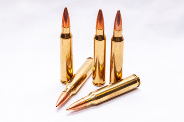 Five .223 caliber bullets on a white background
