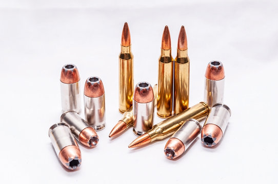 Four different caliber bullets, 223 rifle bullets, 9mm, 40 caliber and 45 auto on a white background