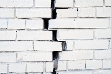 Brick wall with a crack. Bricks diverging in different directions are incorrect construction.