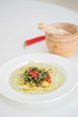 Anti-inflammatory vegan food. Cauliflower and broccoli soup with fresh red chili slices, turmeric and thyme