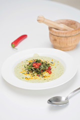 Anti-inflammatory vegan food. Cauliflower and broccoli soup with fresh red chili slices, turmeric and thyme