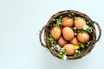 Basket of eggs on a light background, top view.Copy space. Easter concept.