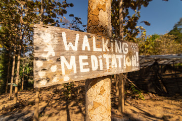 Wooden sign in a meditation retreat with mindfulness inspiration messages in the jungle