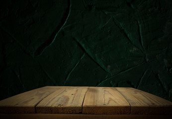 Empty wooden table in front of abstract dark wall background. Can be used to display or edit your products.