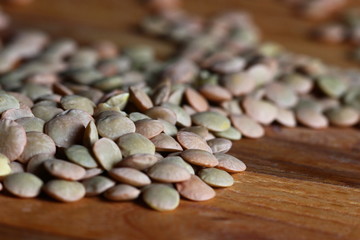 lentil grains scattered on a wooden table